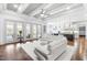 Open living room with hardwood floors, white sectional sofa, and access to a screened porch at 204 Harvest Ln, Pittsboro, NC 27312