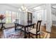 Bright dining room with hardwood floors, chandelier, and large windows at 204 Harvest Ln, Pittsboro, NC 27312