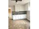 White kitchen cabinets, tiled floor, and access to laundry area at 325 Ranch Farm Rd # A - B, Raleigh, NC 27603