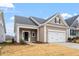 New construction home with tan siding, white garage door, and landscaping at 119 White Oak Gdn Way # 52, Garner, NC 27529