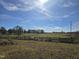 Large pasture with wooden fence and trees in background at 379 John Deere Ln, Bear Creek, NC 27207