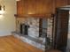 Brick fireplace with brass screen and built-in shelving at 6349 Elevation Rd, Benson, NC 27504