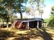 Red outbuilding with covered porch and white columns at 6349 Elevation Rd, Benson, NC 27504