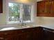 Kitchen features double sink, wood cabinets, and window at 6349 Elevation Rd, Benson, NC 27504