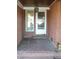Brick front porch with a white door and side windows at 6349 Elevation Rd, Benson, NC 27504