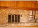 Brick fireplace with brass screen and built-in shelves at 6349 Elevation Rd, Benson, NC 27504