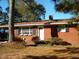 Brick ranch house with covered porch, mature landscaping, and a spacious yard at 6383 Elevation Rd, Benson, NC 27504