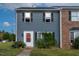 Brick and gray two-story townhome with landscaping and a red front door at 1812 Orange Grove Rd # 101, Hillsborough, NC 27278