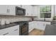 Modern kitchen with white cabinets, dark countertops, and stainless steel appliances at 901 Myers Point Dr # 17, Morrisville, NC 27560