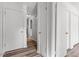 Hallway with light wood flooring, white walls, and closed doors at 14 Stone Village Ct, Durham, NC 27704