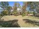 Spacious backyard with a large grassy area and mature trees at 14 Stone Village Ct, Durham, NC 27704