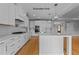 White kitchen features island, stainless steel appliances, and hardwood floors at 5100 Grist Stone Way, Youngsville, NC 27596
