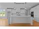 Modern kitchen with white cabinets, large island, and hardwood floors at 5100 Grist Stone Way, Youngsville, NC 27596