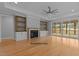 Spacious living room with hardwood floors, fireplace, built-in shelves, and access to a porch at 5100 Grist Stone Way, Youngsville, NC 27596