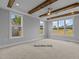 Main bedroom with hardwood floors, exposed wooden beams, and large windows at 5100 Grist Stone Way, Youngsville, NC 27596