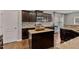 Island kitchen with dark cabinetry and granite countertops at 1221 Chimney Ridge Dr, Fuquay Varina, NC 27526