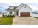 White farmhouse exterior with brown garage door and landscaping at 181 Glenwood Pl, Kenly, NC 27542