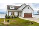 White farmhouse exterior with brown garage door and landscaping at 181 Glenwood Pl, Kenly, NC 27542