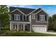 Two story home with gray siding, stone accents, and 3 car garage at 904 Delano Dr, Knightdale, NC 27545