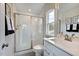 Modern bathroom with a walk-in shower, vanity, and window at 904 Delano Dr, Knightdale, NC 27545