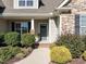 House entrance with a gray door, stone accents, and landscaping at 2168 Mills Crest St, Fuquay Varina, NC 27526