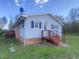 Rear view of a ranch style home with red steps and siding at 376 Gunn Poole Rd, Mebane, NC 27302