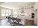 White kitchen island with quartz countertops and gray stools at 2810 Huxley Way, Apex, NC 27502