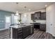 Modern kitchen with dark cabinetry, granite island, and stainless steel appliances at 2830 Huxley Way, Apex, NC 27502