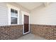 Inviting front entry with a brick facade and a glass storm door at 2117 Attend Xing, Fuquay Varina, NC 27526