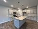 Modern kitchen with light gray cabinets, large island, and stainless steel appliances at 132 S Mistflower St, Clayton, NC 27520