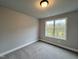 Bright bedroom with neutral carpeting and large window at 132 S Mistflower St, Clayton, NC 27520
