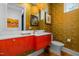 Contemporary powder room with bold red vanity and gold accents at 222 Saint Marys St, Raleigh, NC 27605