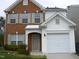 Two-story brick and vinyl home with a two-car garage and landscaped lawn at 142 Brentfield Loop, Morrisville, NC 27560