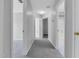 A well-lit hallway with carpeted floors and doors leading to bedrooms and a bathroom at 142 Brentfield Loop, Morrisville, NC 27560
