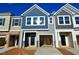 New townhome with gray siding, two-car garage, and landscaping at 693 Leland Hill Cir, Zebulon, NC 27597