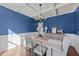 Elegant dining room with blue walls, chandelier, and built-in hutch at 8901 Brook Trout Ln, Willow Springs, NC 27592