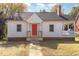Charming white house with red door, brick base, and small front porch at 619 N Mebane St, Burlington, NC 27217
