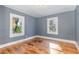 Spacious bedroom with hardwood floors and two windows at 619 N Mebane St, Burlington, NC 27217