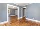 Hardwood floor hallway with gray walls and access to other rooms at 619 N Mebane St, Burlington, NC 27217
