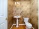 Small half bathroom with pedestal sink and patterned wallpaper at 805 Ledgerock Rd, Wake Forest, NC 27587