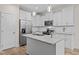 Modern kitchen with white cabinets, granite countertops, and stainless steel appliances at 138 Ottawa Dr, Louisburg, NC 27549