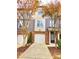 Brick and siding three-story townhome with two-car garage and autumn trees at 4114 Sykes St, Cary, NC 27519