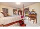 Spacious bedroom with a wooden four-poster bed, and a writing desk at 185 Franklin Ln, Henderson, NC 27537