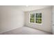 Bright bedroom with large window and neutral carpet at 8659 Brixton Shay Dr, Raleigh, NC 27616