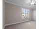 Spacious bedroom with neutral wall colors, carpet flooring, and large window at 129 Pearl St # 6, Garner, NC 27529