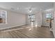 Bright living room with hardwood floors, large windows, and ceiling fan at 129 Pearl St # 6, Garner, NC 27529