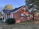 Brick ranch home with a covered porch and landscaped yard at 2222 Sunset Hills Dr, Burlington, NC 27215