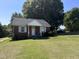 Brick ranch home with a covered porch and yard at 2222 Sunset Hills Dr, Burlington, NC 27215