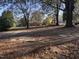 Large backyard with leaf covered ground at 2222 Sunset Hills Dr, Burlington, NC 27215