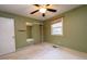 Green bedroom with ceiling fan and mirrored closet doors at 1 Westbury Pl, Durham, NC 27707